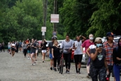 People wait in line to vote in Georgia's primary election outside Park Tavern, June 9, 2020, in Atlanta.