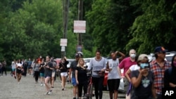 People wait in line to vote in the Georgia's primary election at Park Tavern on Tuesday, June 9, 2020, in Atlanta. (AP Photo/Brynn Anderson)