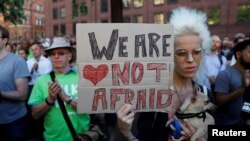 A woman holds a placard as they take part in a vigil for the victims of an attack on concert goers at Manchester Arena, in central Manchester, Britain, May 23, 2017.