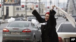 A woman greets participants of a car rally calling for a free presidential election, Moscow, February 19, 2012.