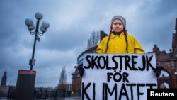 Greta Thunberg memegang spanduk bertuliskan "Pemogokan sekolah untuk iklim" di luar parlemen Swedia di Stockholm, Swedia 30 November 2018. (Foto: Reuters)