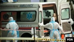 ក្រុមមន្ត្រីសុខាភិបាលស្ថិតក្នុងឯកសណ្ឋានការពារពីការឆ្លងជំងឺកូវីដ១៩ បញ្ជូនអ្នកជំងឺកូវីដ១៩ មកទទួលការព្យាបាលនៅមណ្ឌលព្យាបាល នៅកោះពេជ្រ រាជធានីភ្នំពេញ ថ្ងៃទី១៥ ខែមេសា ឆ្នាំ២០២១។ (ហ៊ាន សុជាតា/វីអូអេ)