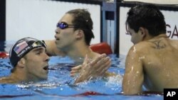 United States’ Michael Phelps, left, congratulates Singapore’s Joseph Schooling for his gold in the men’s 100-meter butterfly final during the swimming competitions at the 2016 Summer Olympics, Friday, Aug. 12, 2016.