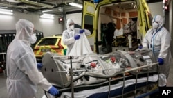 Petugas medis memindahkan pasien ke ambulans untuk dipindahkan ke rumah sakit lain dari Rumah Sakit MontLegia di Liege, Belgia, Jumat, 31 Oktober 2020. (Foto: dok).
