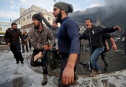 FILE - Men carry the body of a man retrieved from the rubble of a building following an airstrike by government for on a vegetable market in Syria's last major opposition bastion of Idlib, Jan. 15, 2020