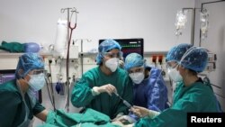 Members of the medical staff treat a patient at the intensive care unit (ICU) of the Sotiria hospital, amid the coronavirus disease (COVID-19) pandemic, in Athens, Greece, March 18, 2021.