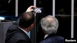 Brazil's Financial Minister Paulo Guedes takes a photo with Senator Flavio Bolsonaro following a vote on pension reform in Brasilia, Brazil, Oct. 22, 2019. 