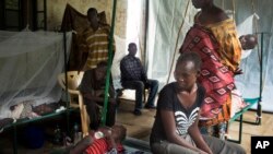 FILE - In this May 24, 2014 file photo a South-Sudanese family waits in the cholera isolation ward of Juba Teaching Hospital in the capital Juba. 