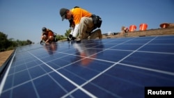 Des techniciens travaillent sur un panneau solaire, Mission Viejo, Californie, le 25 octobre 2013