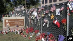 حملے کا نشانہ بننے والے مرکز کے باہر تعزیتی پھول اور امریکی پرچم۔ (فائل فوٹو)