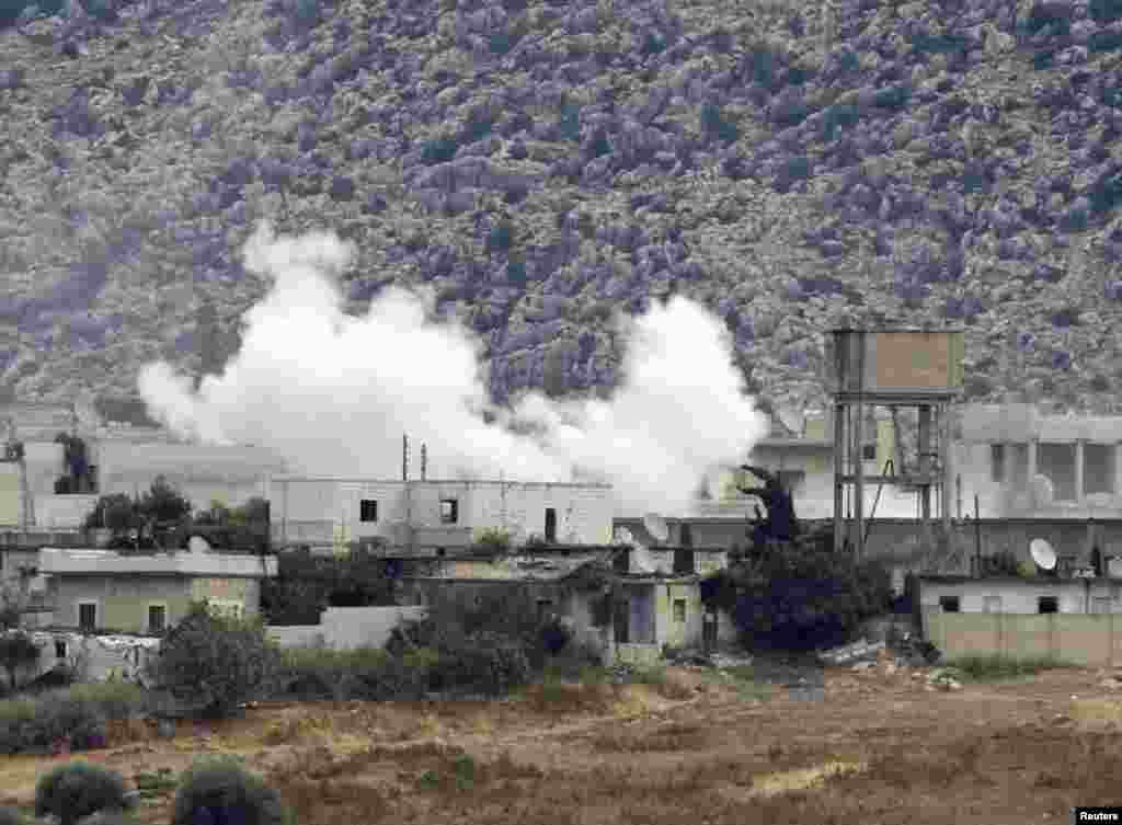 Smoke, caused by mortar bombs and gunfire during clashes between the Syrian Army and rebels, rises from the Syrian border town of Azmarin as seen from the Turkish-Syrian border near the village of Hacipasa in Hatay province October 11, 2012.