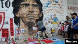 Warga Argentina berduka cita atas meninggalnya legenda sepakbola Diego Armando Maradona, di luar stadion Diego Armando Maradona di Buenos Aires, Argentina Rabu (25/11). 
