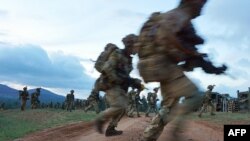 Des soldats traversent une route lors d'un exercice militaire simulé de l'unité d'entraînement de l'armée britannique au Kenya (BATUK) avec les Forces de défense du Kenya (KDF) au ranch ol-Daiga, haut sur le plateau de Laikipia au Kenya, le 26 mars 2018.