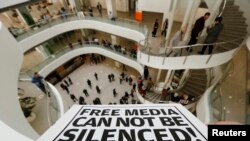 FILE - A Zaman journalist holds a banner at the headquarters of Zaman daily newspaper in Istanbul, Dec. 14, 2014. 