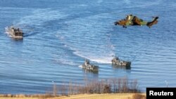 Landing craft and a helicopter are seen during NATO's Exercise Trident Juncture, off the Trondheim coast, Norway, Oct. 30, 2018. Finland says Russia disrupted its GPS signals during NATO exercises in the region earlier this month.