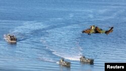 Landing craft and a helicopter are seen during NATO's Exercise Trident Juncture, off the Trondheim coast, Norway, Oct. 30, 2018.