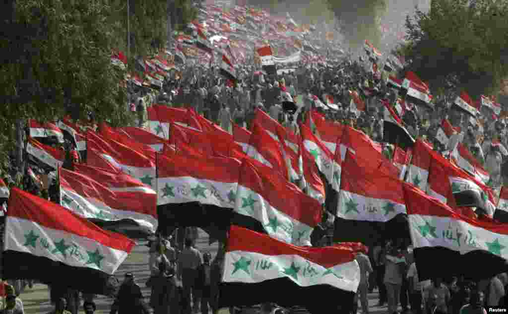 Demonstrators wave Iraqi flags during an anti-U.S. protest called by fiery cleric Moqtada al-Sadr in Najaf, marking the fourth anniversary of the fall of Baghdad, April 9, 2007.
