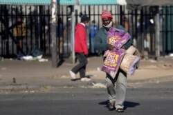A demonstrator walks after looting a store during protests following the imprisonment of former South Africa President Jacob Zuma, in Katlehong, South Africa, July 12, 2021.