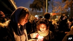 People gather for a candlelight vigil for the victims of the Ukraine plane crash, at the gate of Amri Kabir University that some of the victims of the crash had attended, in Tehran, Iran, Jan. 11, 2020.