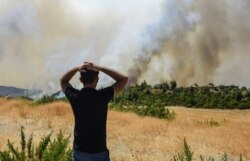 A man watches wildfires in Kacarlar village near the Mediterranean coastal town of Manavgat, Antalya, Turkey, July 31, 2021.