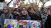 A student holds a sign as she joins a large crowd gathered to protest some of President elect Donald Trump policies and to ask school officials to reject his plans at Rutgers University.