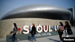 មនុស្សម្នា​ដែល​ពាក់​ម៉ាស់​ដើម្បី​ការពារ​ការ​ឆ្លង​មេរោគ​កូរ៉ូណា​ដើរ​នៅ​តាម​ផ្លូវ​មួយ​នៅ​ក្នុង​ក្រុង​សេអ៊ូល ប្រទេស​កូរ៉េខាងត្បូង កាលពី​ថ្ងៃទី២៥ ខែមីនា ឆ្នាំ២០២០។