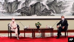 In this photo provided by the U.S. Department of State, U.S. Deputy Secretary of State Wendy Sherman, left, and Chinese Foreign Minister Wang Yi sit together in Tianjin, China, Monday, July 26, 2021. China came out swinging at high-level face-to…