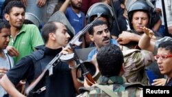 Polisi dan pendukung pemerintah Mesir di luar masjid al-Fatah di Kairo (17/8). (Reuters/Muhammad Hamed)