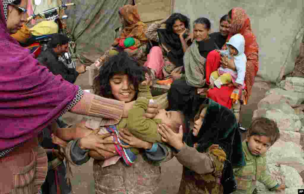 A Pakistani health worker gives a polio vaccine to a child in the slums of Lahore. Militants oppose vaccination against polio and consider such campaigns a cover for spying and also claim the vaccine is intended to make Muslim boys sterile.
