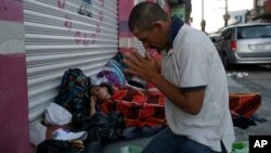 Marvin Sanabria, a Central American migrant traveling with a caravan to the U.S., kneels in prayer after waking up, in Huixtla, Mexico, Oct. 23, 2018. 