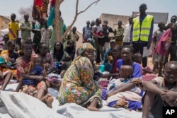 FILE - South Sudanese who fled from Sudan sit outside a nutrition clinic at a transit center in Renk, South Sudan, on May 16, 2023.
