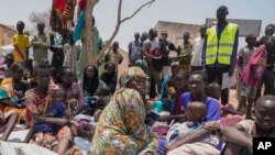 FILE - South Sudanese who fled from Sudan sit outside a nutrition clinic at a transit center in Renk, South Sudan, on May 16, 2023.