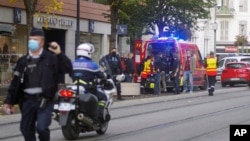 French policemen and firemen stand next to Notre Dame church after a knife attack, in Nice, France, Oct. 29, 2020.