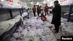 A relative waits while volunteers search for a body of a deceased among people who died due to an intense heat wave in Karachi, Pakistan, June 22, 2015. (PHOTO / REUTERS / Akhtar Soomro)
