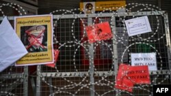 បដាប្រឆាំងនឹងអគ្គមេបញ្ជាការយោធាមីយ៉ាន់ម៉ាលោក Min Aung Hlaing ត្រូវបានឃើញនៅលើរបងដែលមានរុំដោយលោះ ខណៈក្រុមបាតុករប្រមូលគ្នាតវ៉ាប្រឆាំងរដ្ឋប្រហារយោធានៅទីក្រុងរ៉ង់ហ្គូន ប្រទេសមីយ៉ាន់ម៉ា កាលពីថ្ងៃទី២២ ខែកុម្ភៈ ឆ្នាំ២០២១។ 