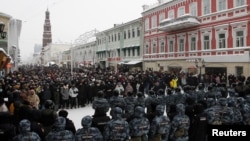 Law enforcement officers stand in front of participants during a rally in support of jailed Russian opposition leader Alexei Navalny in Kazan, Russia, Jan. 23, 2021.