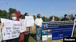 People carry signs as they condemn the remarks by Prime Minister Imran Khan, during a protest in Islamabad, Pakistan, April 8, 2021.