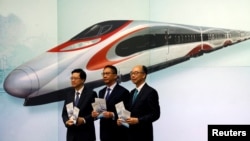 Secretary for Security John Lee, from left, Secretary for Justice Rimsky Yuen and Secretary for Transport & Housing Frank Chan pose at a news conference on arrangements at West Kowloon Terminus for the Guangzhou-Shenzhen-Hong Kong Express Rail Link in Kong, July 25, 2017.