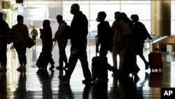 FILE - Air travelers line up to go through a a security checkpoint at Salt Lake City International Airport in Salt Lake City, on Nov. 25, 2020. 