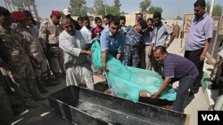 Warga Irak sedang mengurus jenazah korban tewas akibat serangan hari Selasa (13/9).