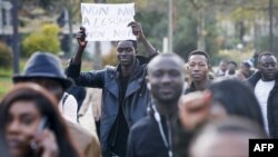 Un homme brandit une affiche mentionnant "Non non à l'esclavage" au cours d'une marche contre "l'esclavage en Libye", Paris, 18 novembre 2017.
