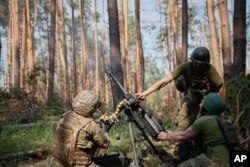 Tentara Ukraina menembakkan peluncur granat ke arah posisi Rusia di garis depan dekat Kreminna, wilayah Luhansk, Ukraina, Kamis, 8 Juni 2023. (Roman Chop via AP)