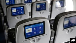 This March 16, 2017, photo shows the interior of a JetBlue airliner at John F. Kennedy International Airport in New York. Government figures show that U.S. airlines are improving at flying on time, handling baggage and not bumping as many passengers. Complaints are down too. 