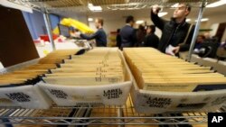 FILE - In this Oct. 31, 2018, file photo, early ballots wait in bins to be sorted in the Denver Elections Division headquarters in Denver, Colorado. (AP Photo/David Zalubowski, File) 