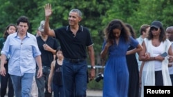 FILE - Former U.S. President Barack Obama waves while walking with his daughter Mali and his wife Michelle during a visit to the 9th-century Borobudur Temple in Magelang, Indonesia June 28, 2017. (REUTERS/Pius Erlangga)