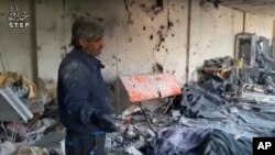 In this still image made from video provided by opposition operated Step News Agency, which is consistent with independent AP reporting, a man views scenes of destruction inside a banquet hall, in Deir Qanoun, Barada Valley, Syria, Jan. 15, 2017 
