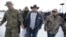 Ammon Bundy, center, one of the sons of Nevada rancher Cliven Bundy, walks off after speaking with reporters during a news conference at Malheur National Wildlife Refuge headquarters, Jan. 4, 2016, near Burns, Ore.