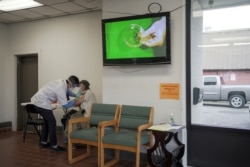 FILE - Rodney Nourse, 71, receives a Moderna coronavirus disease (COVID-19) vaccination from pharmacist Phat Quach at Broad Avenue Pharmacy in New Orleans, Louisiana, Jan. 8, 2021.