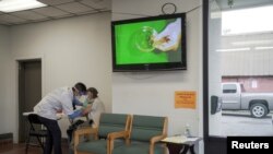 FILE - Rodney Nourse, 71, receives a Moderna coronavirus disease (COVID-19) vaccination from pharmacist Phat Quach at Broad Avenue Pharmacy in New Orleans, Louisiana, Jan. 8, 2021. 