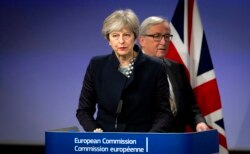 FILE - European Commission President Jean-Claude Juncker, right, walks behind British Prime Minister Theresa May prior to addressing a media conference at EU headquarters in Brussels, Dec. 4, 2017.